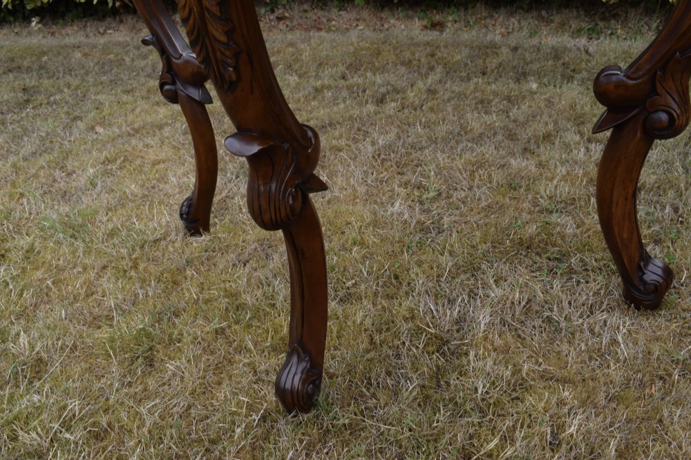 A dark mahogany demi-lune console table featuring deep acanthus leaf carvings on the frieze and three cabriole legs. View IX
