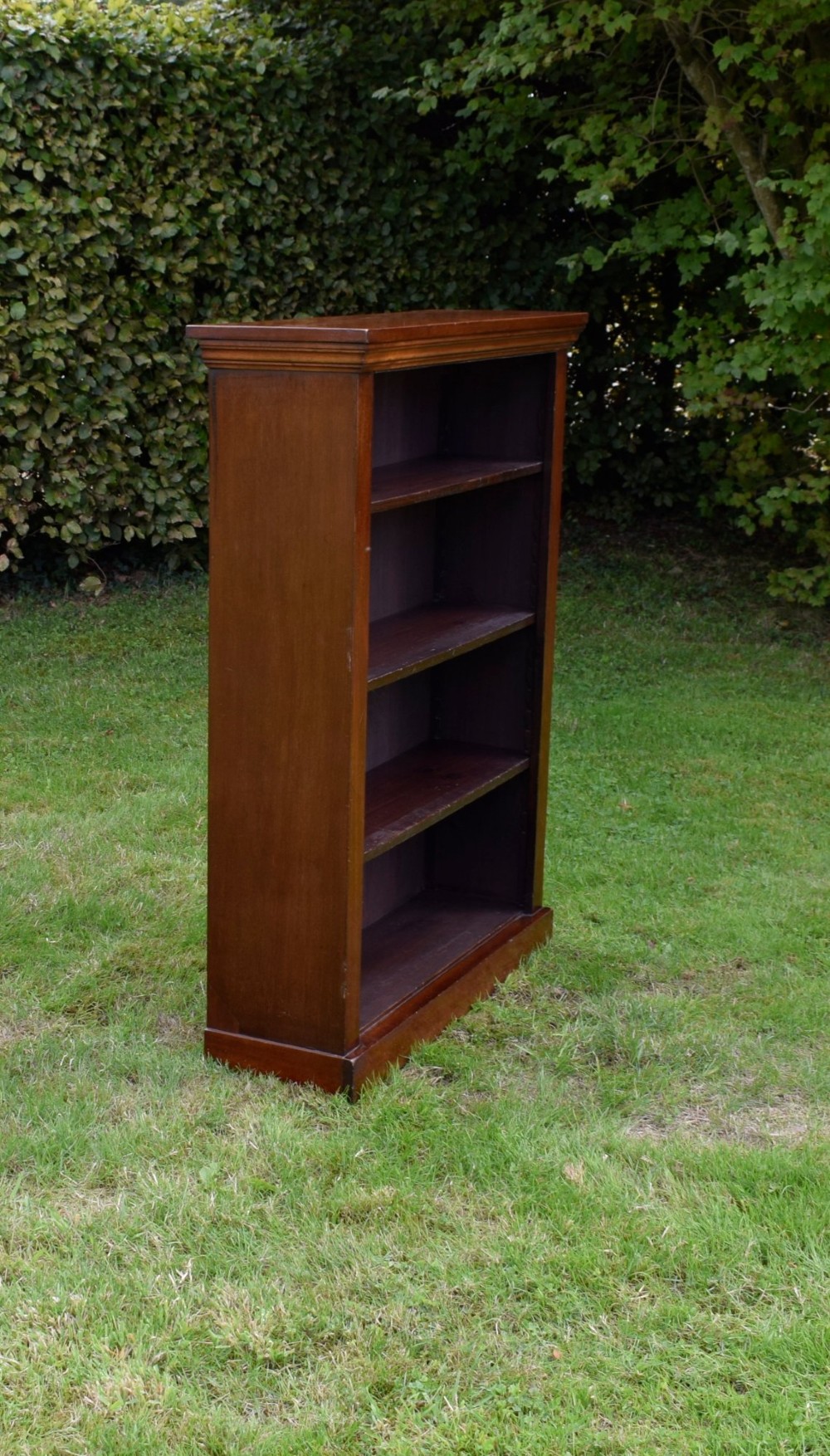 An early 20th-century open-front mahogany bookcase featuring three internal shelves, a moulded top cornice, and a sturdy plinth base. View III