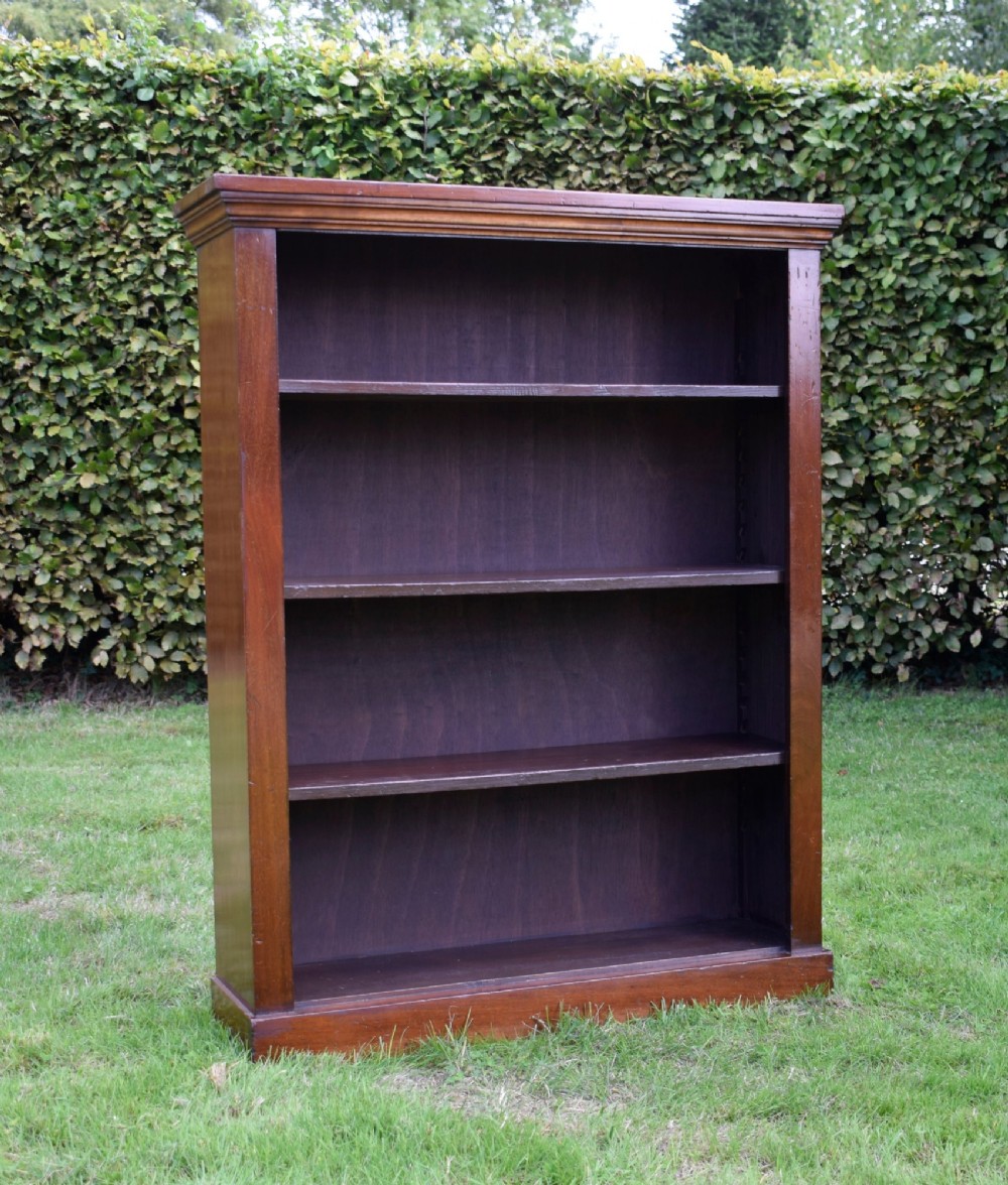 An early 20th-century open-front mahogany bookcase featuring three internal shelves, a moulded top cornice, and a sturdy plinth base. View VI