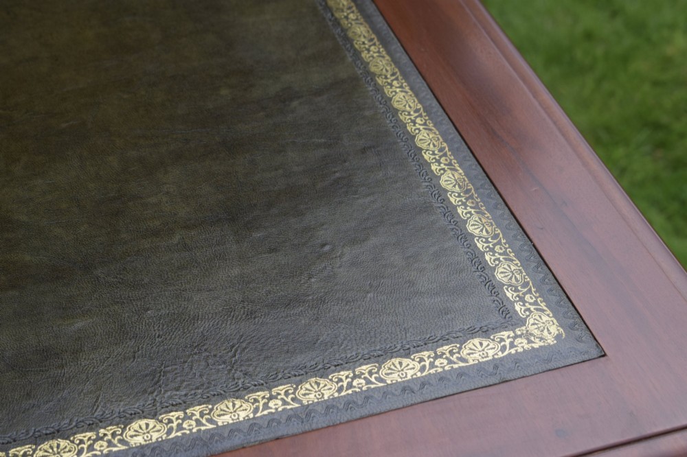 A Victorian warm brown mahogany writing table featuring an inset green leather writing surface, two drawers with knob handles, and turned legs. View XIII