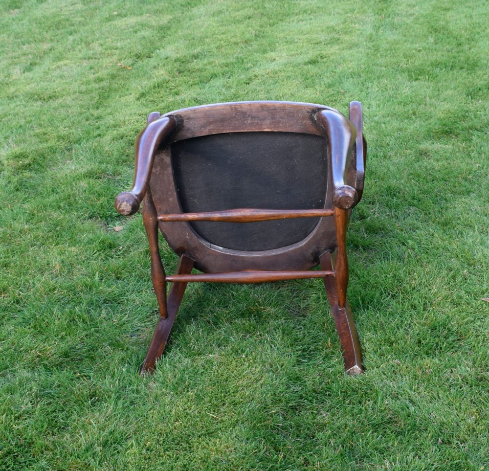 A late Victorian wooden desk armchair with a curved slatted backrest, curved arms, and a tan leather seat trimmed with studding. View XV