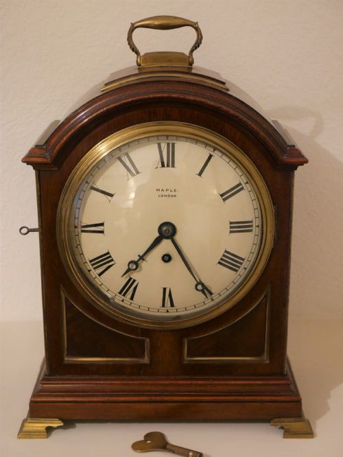 A brass detailed bracket clock retailed by Maple of London.