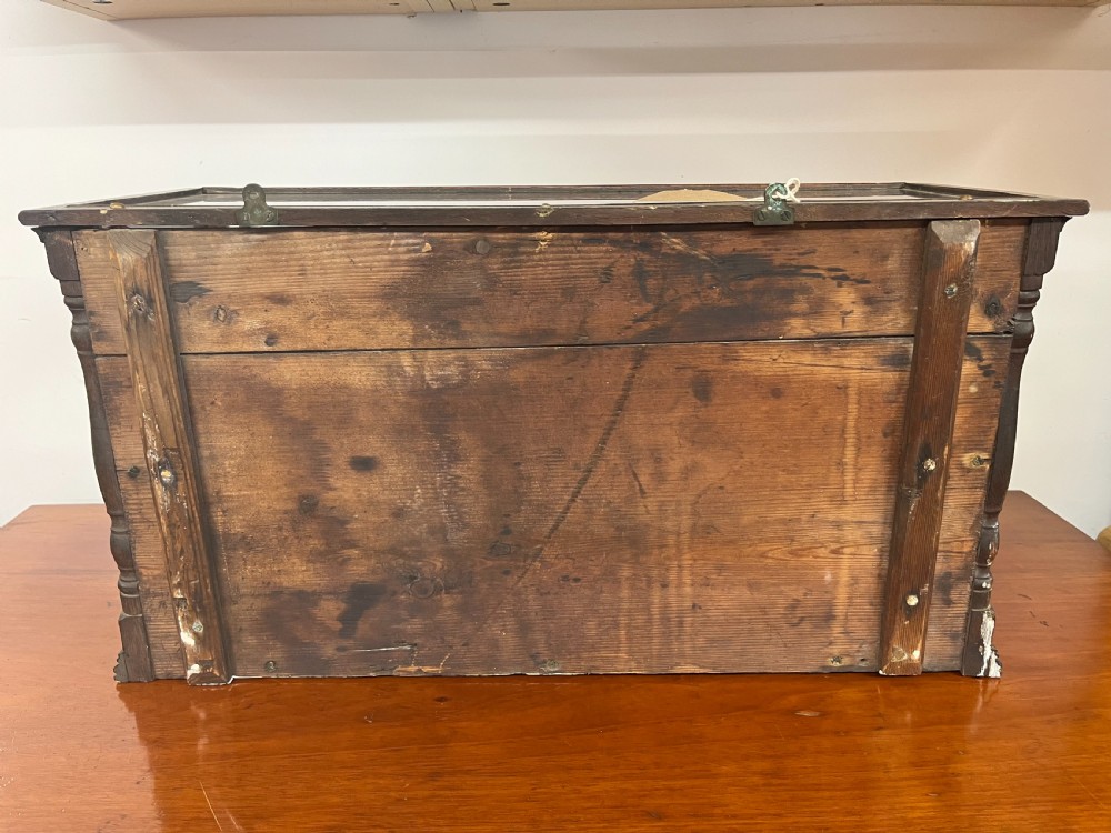 A 19th-century English ship diorama featuring a detailed three-masted sailing vessel set against a painted ocean background inside a glazed wooden case with turned corner posts. View VI