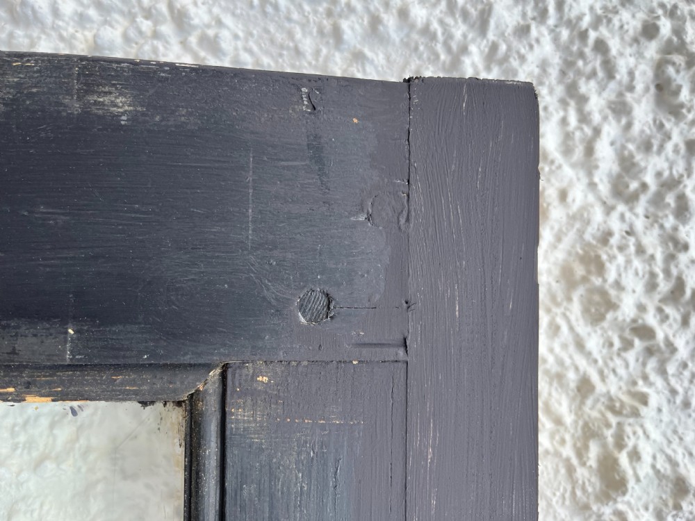 An antique black painted timber door featuring an Art Nouveau leaded glass window with an amber border and a painted central portrait roundel. View VI
