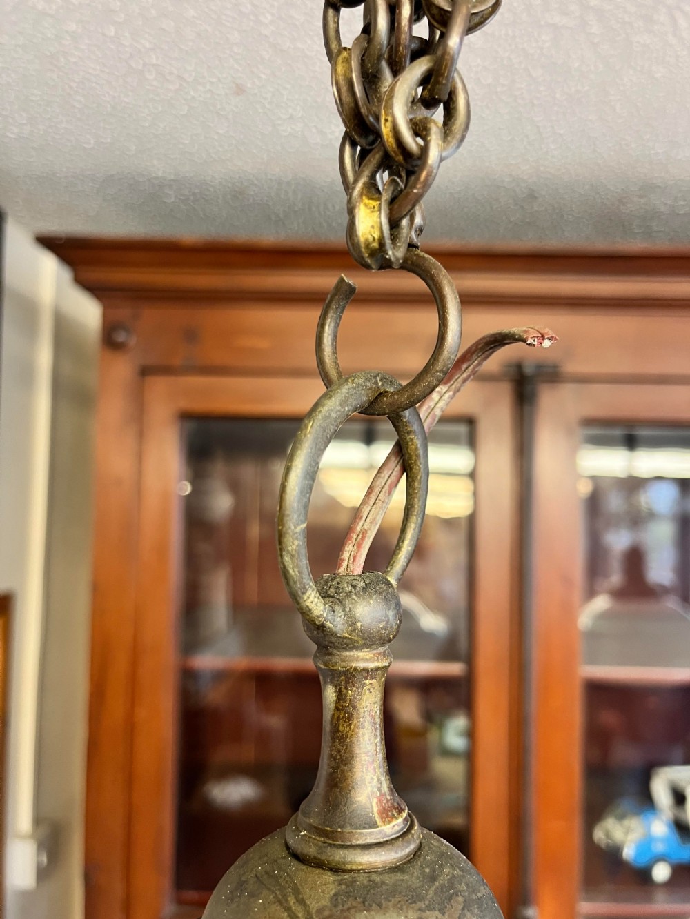 An early 20th-century white opaline glass chapel pendant light featuring a wide rounded shade, an aged brass gallery, and a suspension chain. View II