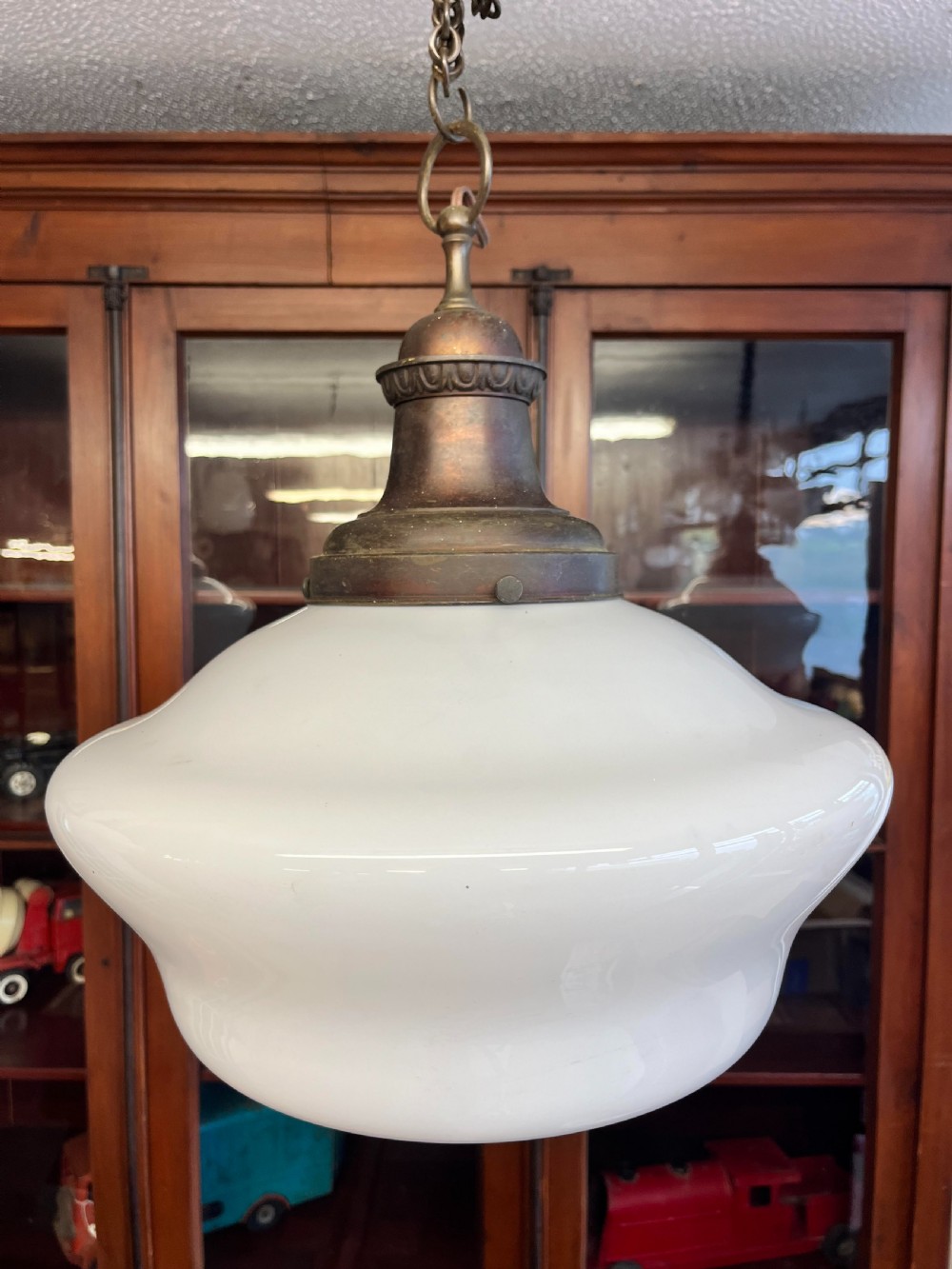 An early 20th-century white opaline glass chapel pendant light featuring a wide rounded shade, an aged brass gallery, and a suspension chain. View III