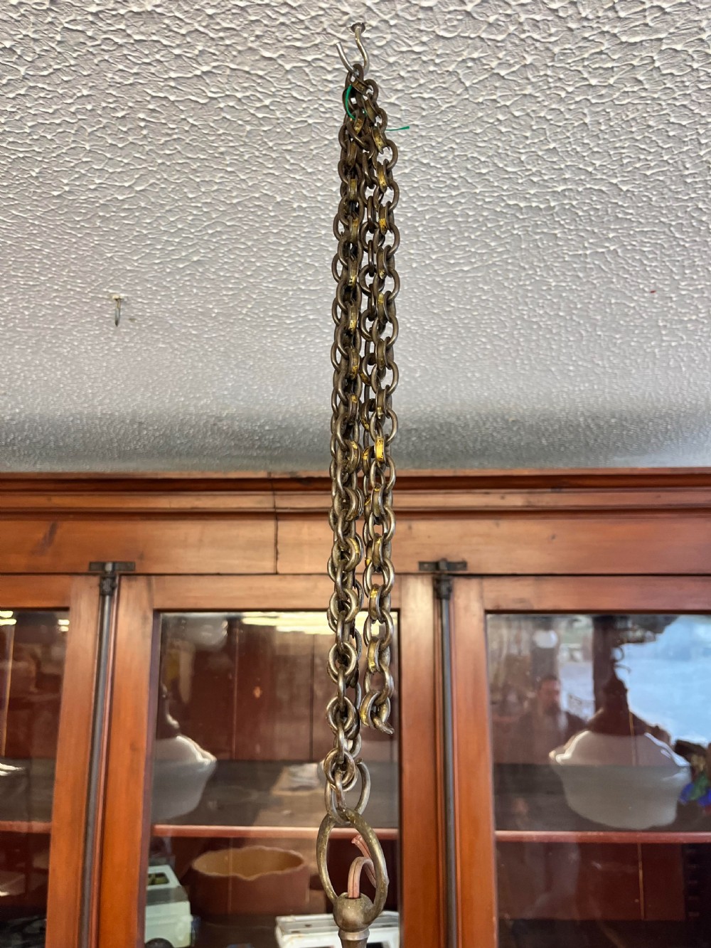 An early 20th-century white opaline glass chapel pendant light featuring a wide rounded shade, an aged brass gallery, and a suspension chain. View IV