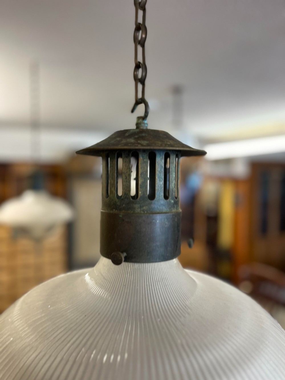 An early twentieth-century double prismatic holophane glass pendant light with a slotted metal gallery and suspension hook. View II