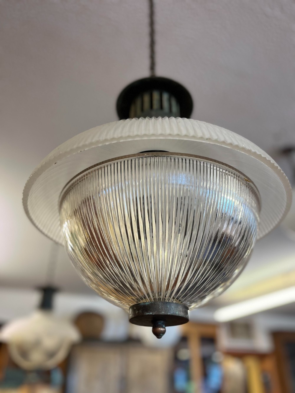 An early twentieth-century double prismatic holophane glass pendant light with a slotted metal gallery and suspension hook. View V