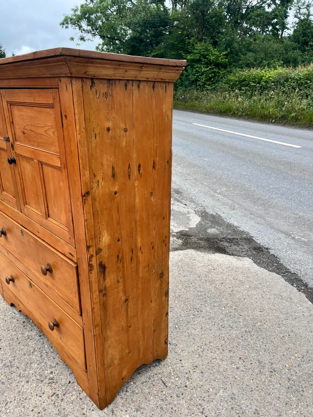 An early 19th-century Georgian pine linen cupboard featuring two upper panelled doors over two wide drawers with wooden turned knobs. View IV