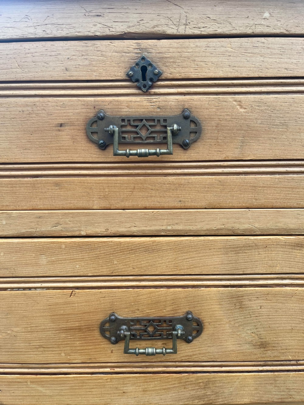 A Victorian pine dressing chest featuring a central swivel mirror flanked by two small trinket drawers, positioned above a base containing two short drawers and two long drawers with metal drop handles. View II