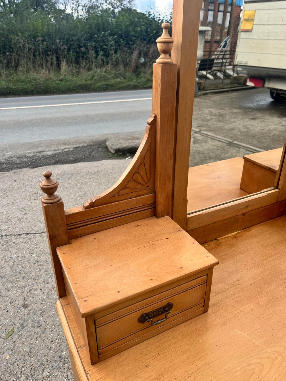 A Victorian pine dressing chest featuring a central swivel mirror flanked by two small trinket drawers, positioned above a base containing two short drawers and two long drawers with metal drop handles. View V