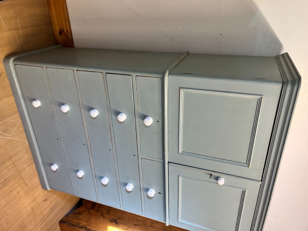 A tall Victorian painted pine linen cupboard featuring a top double-door cupboard set above five drawers with white turned handles. View IV