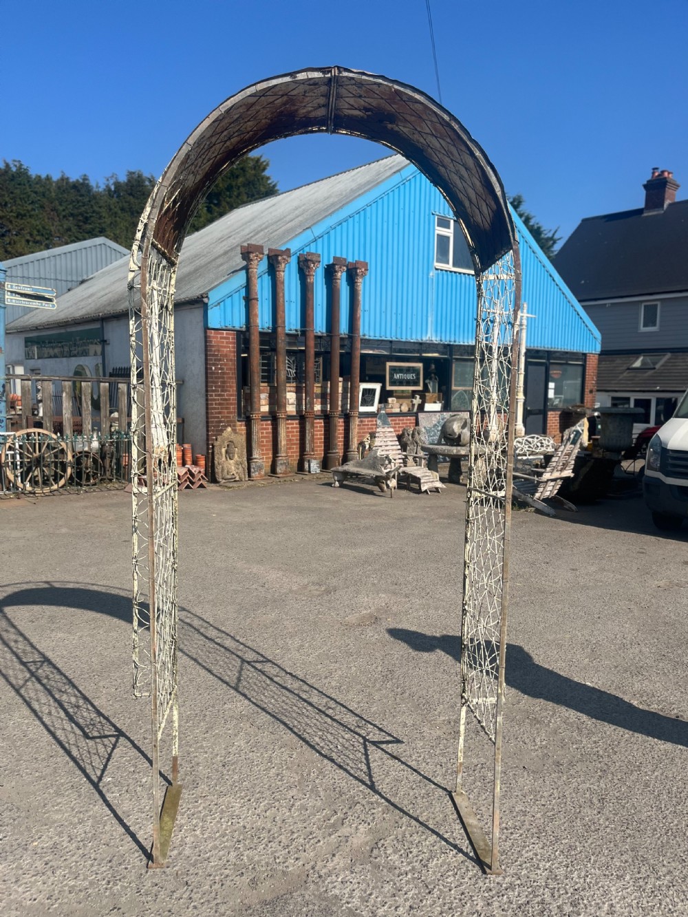 A tall early 20th-century wrought iron garden arch featuring interlocking circular side panels, a wirework canopy, and a weathered cream painted finish. View IV