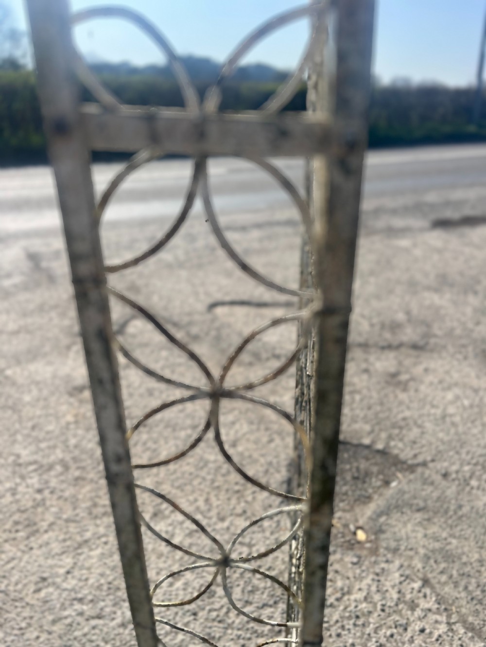 A tall early 20th-century wrought iron garden arch featuring interlocking circular side panels, a wirework canopy, and a weathered cream painted finish. View VII