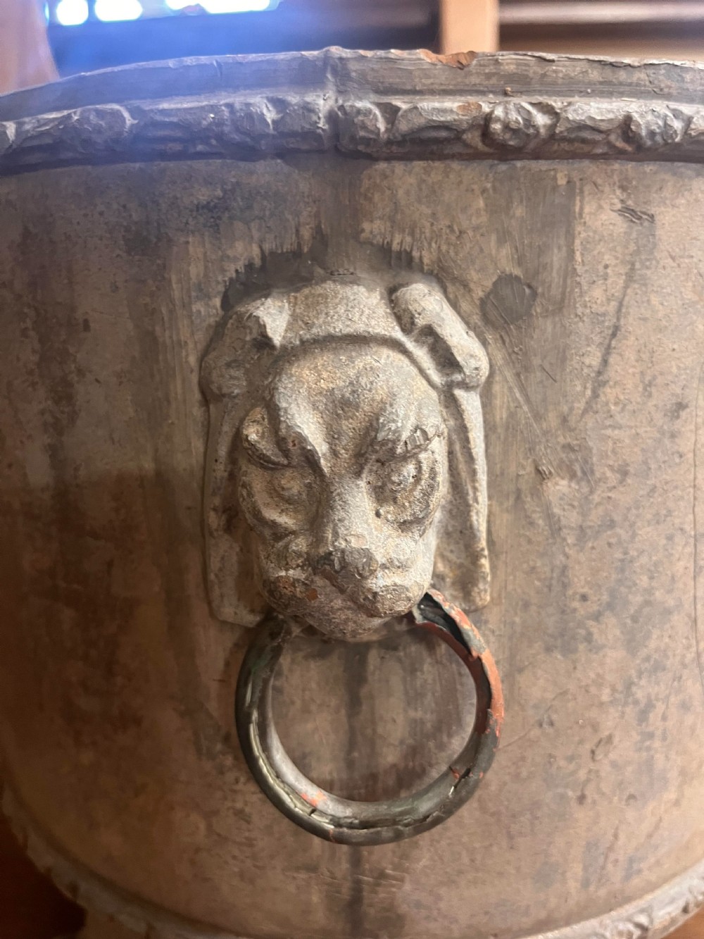 A 19th-century cylindrical weathered lead garden planter featuring a central oval medallion with a cherub relief, side lion mask handles, and four claw feet. View VII