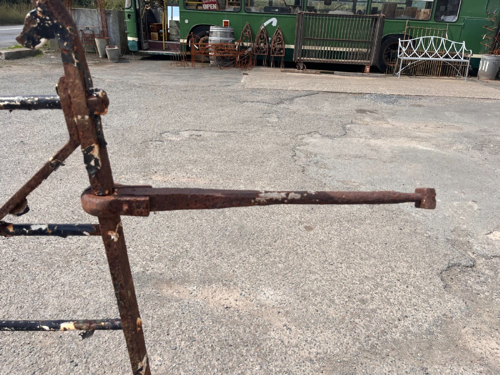 A pair of black 19th-century wrought iron garden gates featuring horizontal bars, diagonal cross braces, and scrolled top terminals. View X