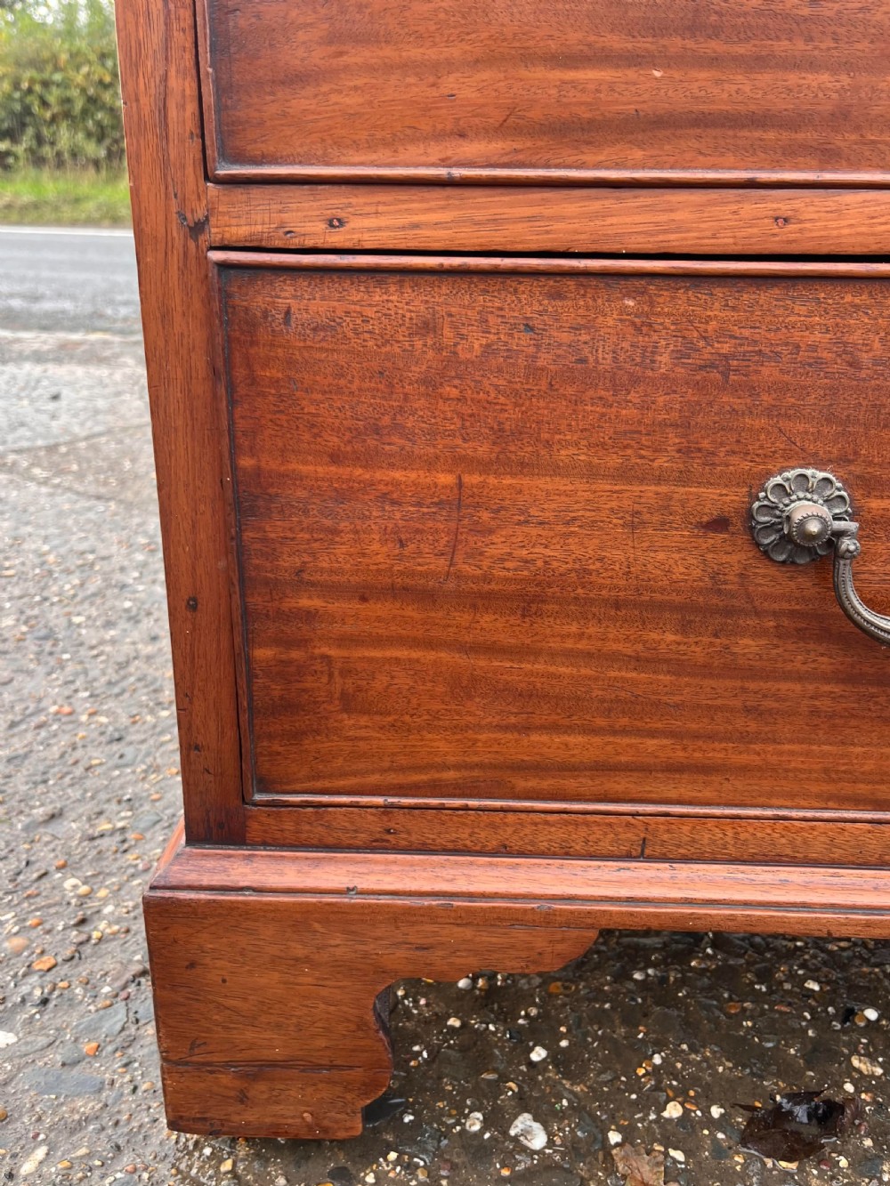 An early nineteenth-century Georgian mahogany chest of drawers with two short over three long drawers, brass drop handles, and bracket feet. View II