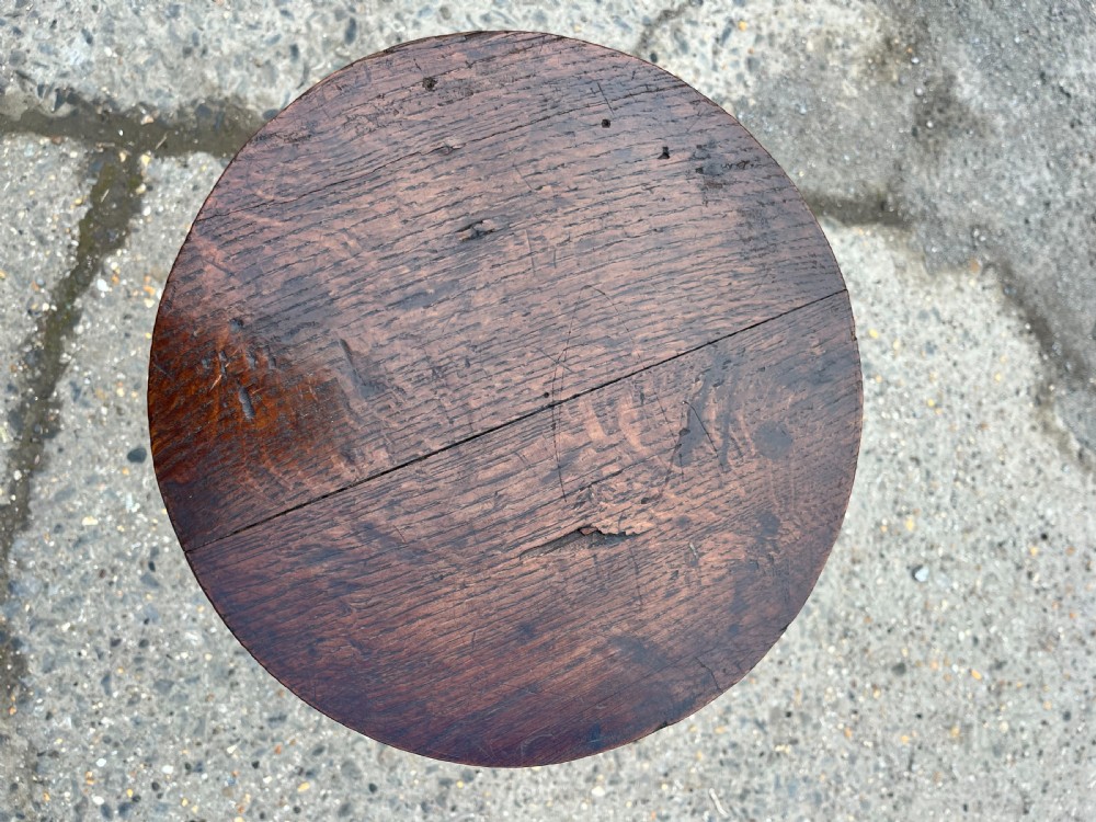 An 18th-century dark wood candle stand with a circular top, baluster-turned central stem, and tripod base. View III
