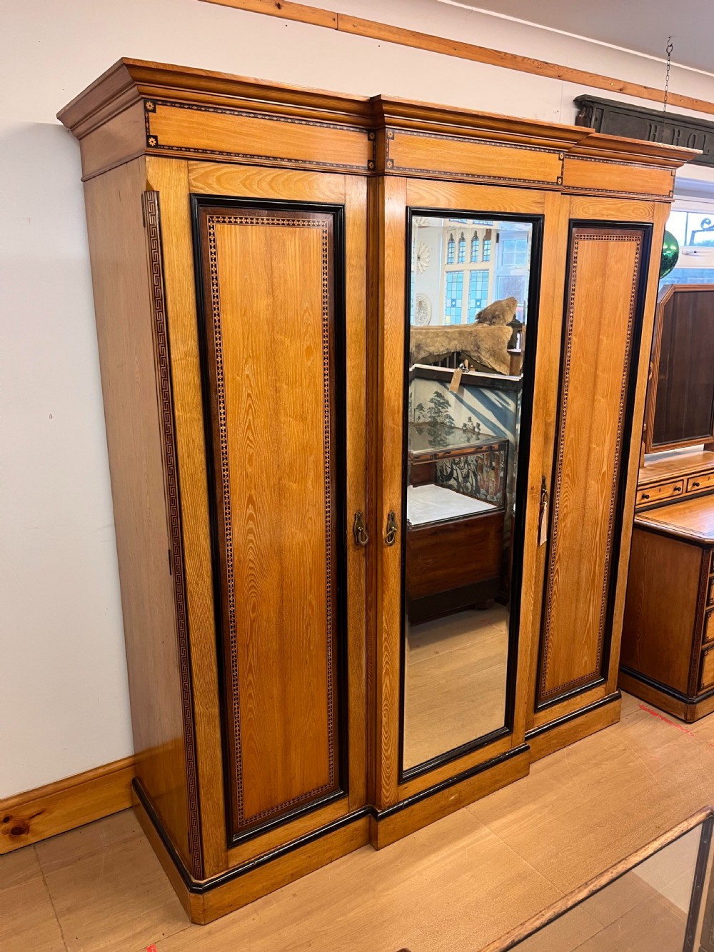 An Ash Aesthetic Movement Triple Wardrobe by A.W. Taylor & Sons with Painted Geometric Detail  