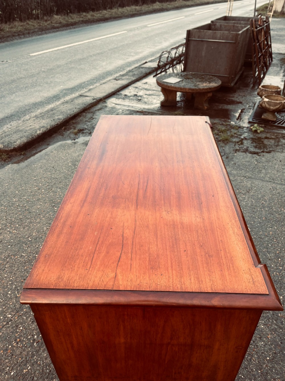 A late Georgian mahogany chest of drawers featuring two short drawers over four long graduated drawers with turned handles and brass keyhole escutcheons. View IV