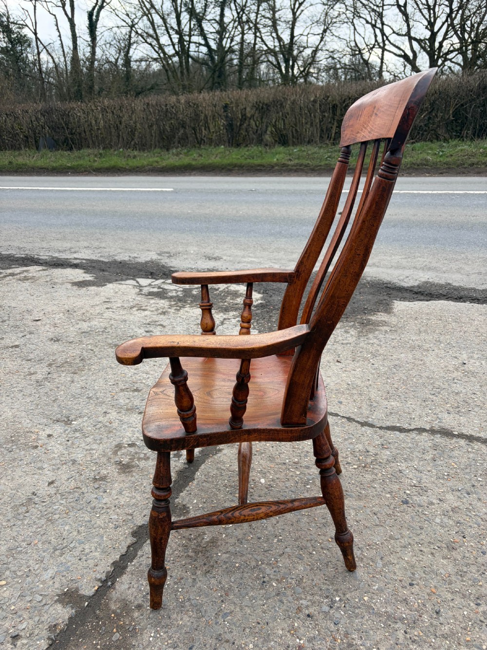 A Victorian ash and elm Windsor carver chair featuring shaped armrests, turned front legs, vertical back spindles, and a contoured wooden seat. View III