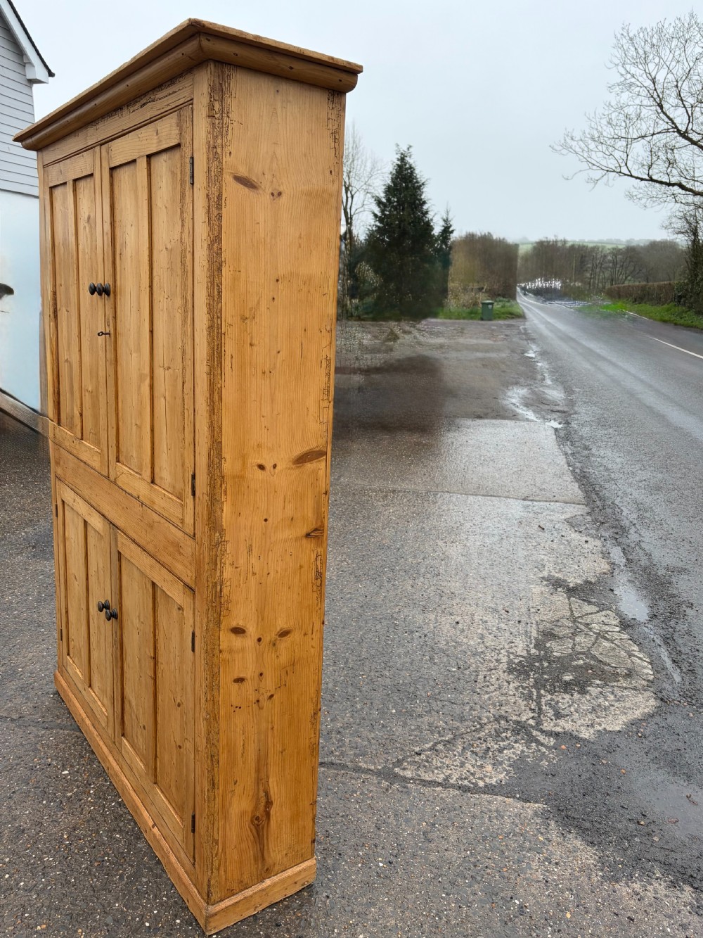 A tall Victorian pine cupboard with four framed panel doors, turned wooden knobs, and a natural waxed finish. View VIII