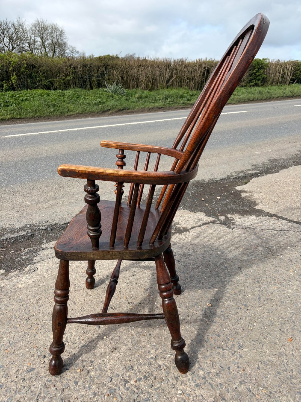 A 19th-century dark elm and beech Windsor armchair featuring a pierced central splat, hoop back, turned spindles, and turned legs. View II