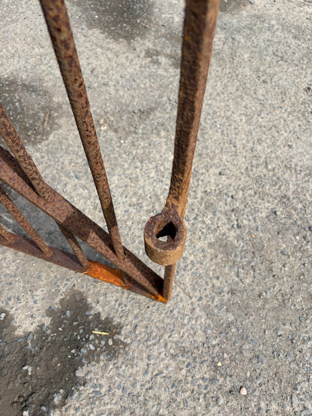 A tall late 19th-century wrought iron gate featuring an arched top rail, vertical bars, riveted joinery, and a rusted surface patina. View III