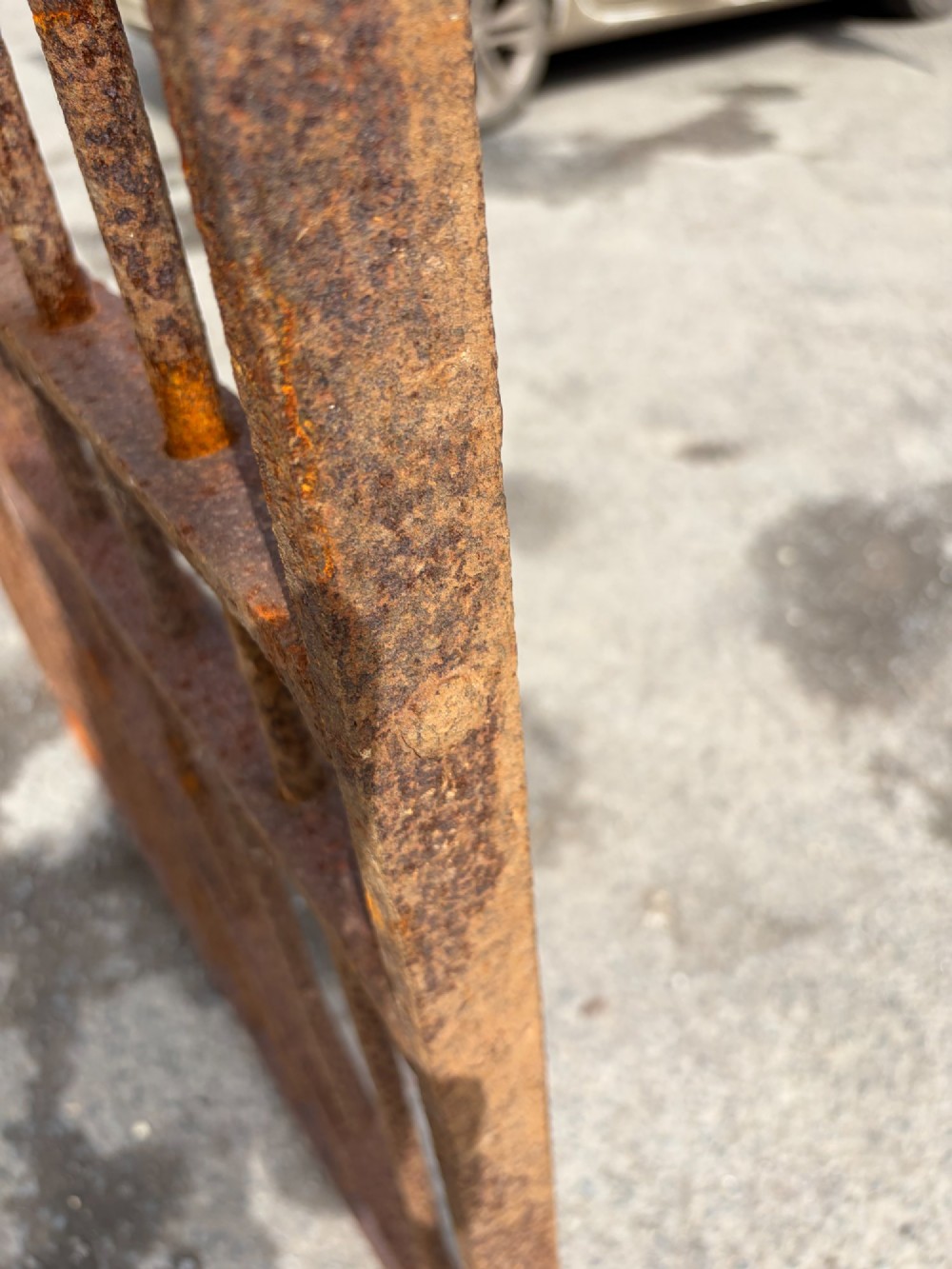 A tall late 19th-century wrought iron gate featuring an arched top rail, vertical bars, riveted joinery, and a rusted surface patina. View IV