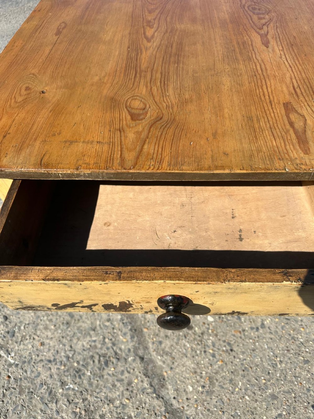 A Victorian pine table featuring a natural wood top, a single drawer with a round wooden knob, and turned yellow painted legs showing light surface wear. View II
