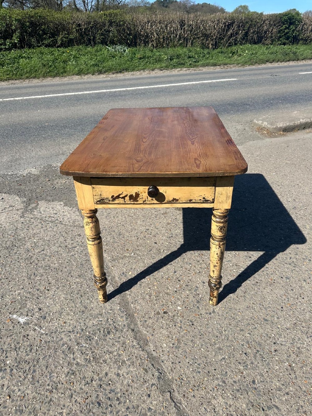 A Victorian pine table featuring a natural wood top, a single drawer with a round wooden knob, and turned yellow painted legs showing light surface wear. View IX