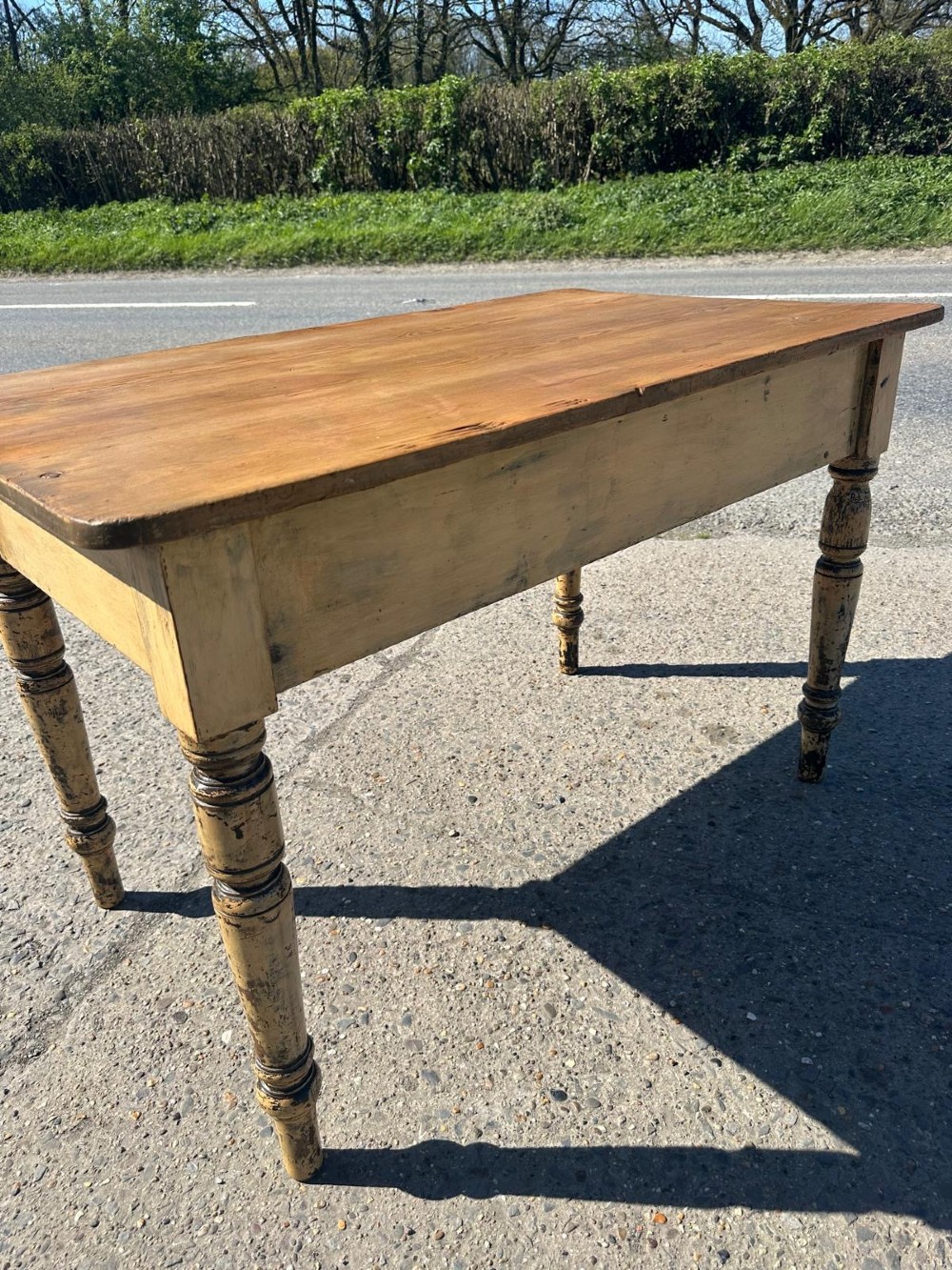 A Victorian pine table featuring a natural wood top, a single drawer with a round wooden knob, and turned yellow painted legs showing light surface wear. View XII