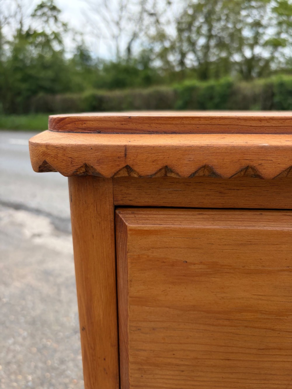 A Victorian pine chest of drawers featuring two short over three long graduated drawers with brass handles and carved edge trim. View IX