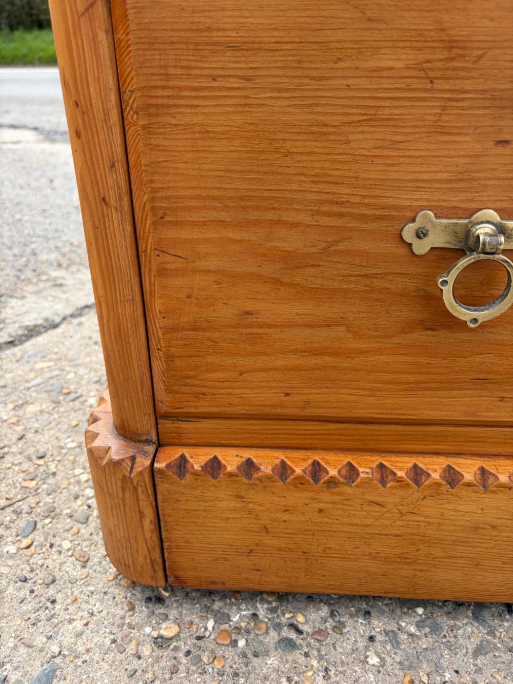 A Victorian pine chest of drawers featuring two short over three long graduated drawers with brass handles and carved edge trim. View XII