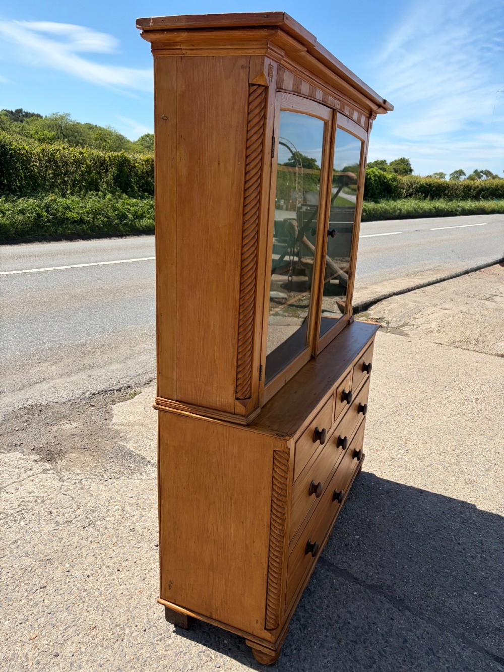 A Victorian pine Cornish dresser featuring a two-door glazed upper display cabinet over a base containing five drawers with turned wooden knobs. View VII