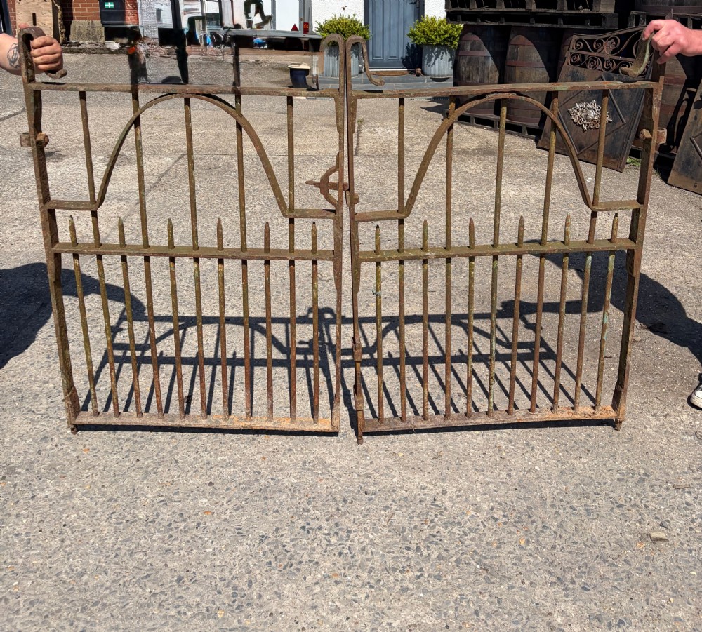 A pair of Victorian wrought iron garden gates featuring vertical bars, arched internal rails, and scroll top embellishments with a natural rusted finish. View II