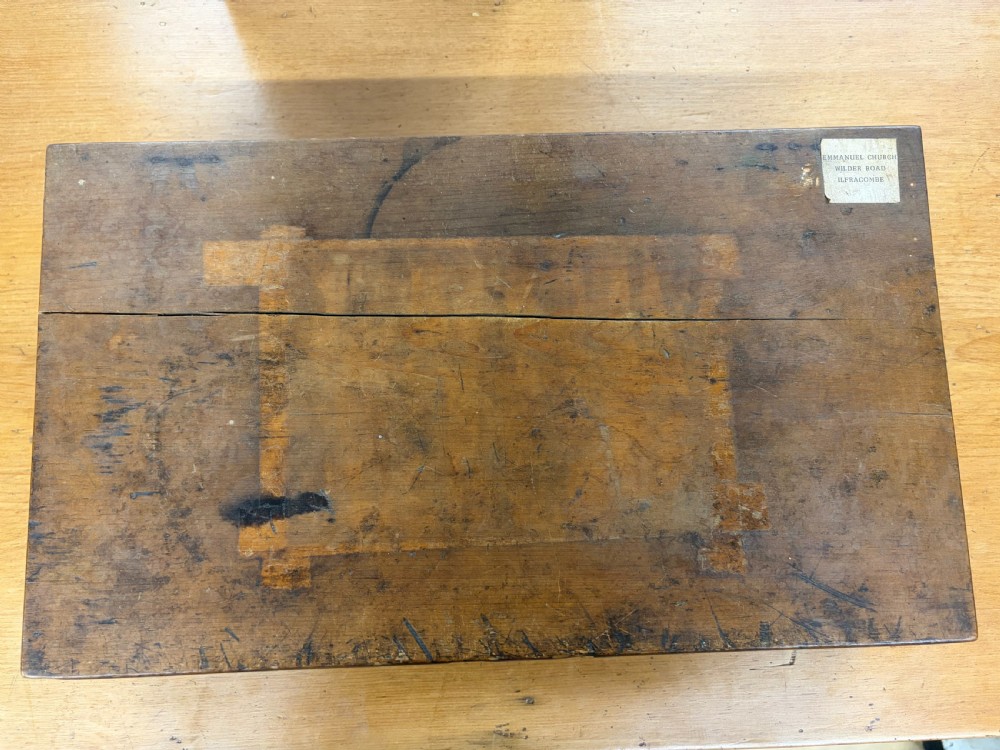 An antique Edwardian dark wood church hymn board with slotted rails holding printed cards for Hymn, Tune, and number digits. View III