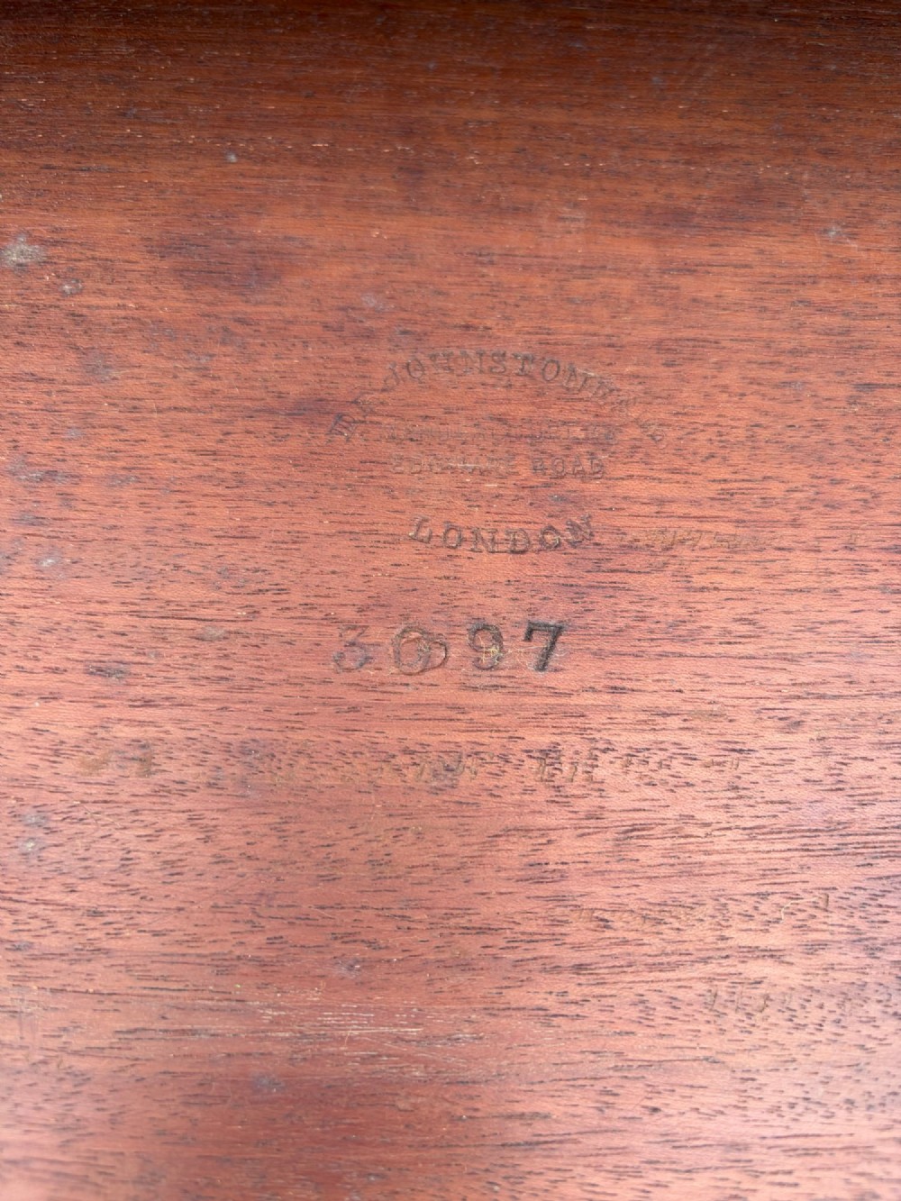 A Victorian walnut canterbury with pierced fretwork dividers, turned corner posts, finials, a lower drawer, and brass castors. View IV