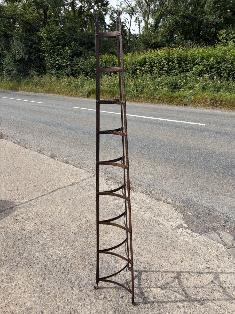 A tall nine-tiered wrought iron pan stand featuring graduated triangular tiers and scrolled detailing at the top. View II