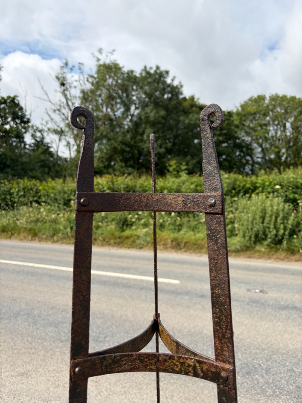 A tall nine-tiered wrought iron pan stand featuring graduated triangular tiers and scrolled detailing at the top. View III