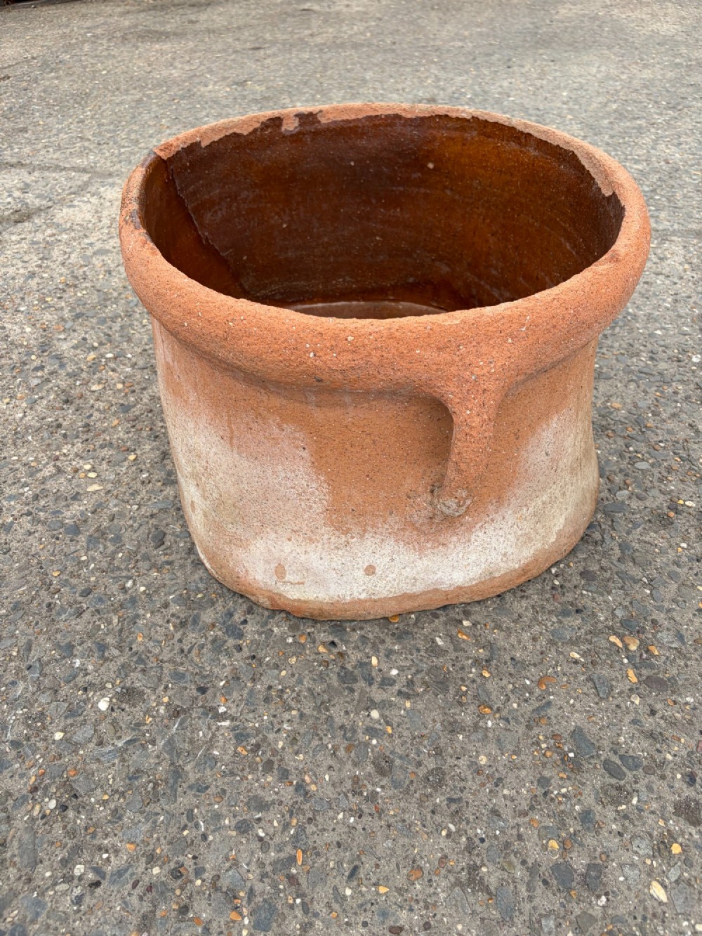 A large 19th-century oval terracotta salting trough with a weathered unglazed exterior and an amber lead-glazed interior. View II