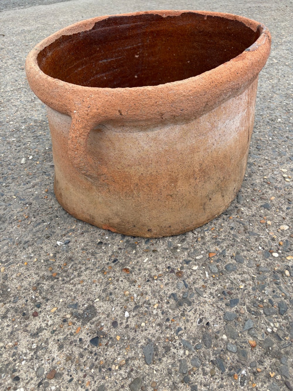 A large 19th-century oval terracotta salting trough with a weathered unglazed exterior and an amber lead-glazed interior. View III