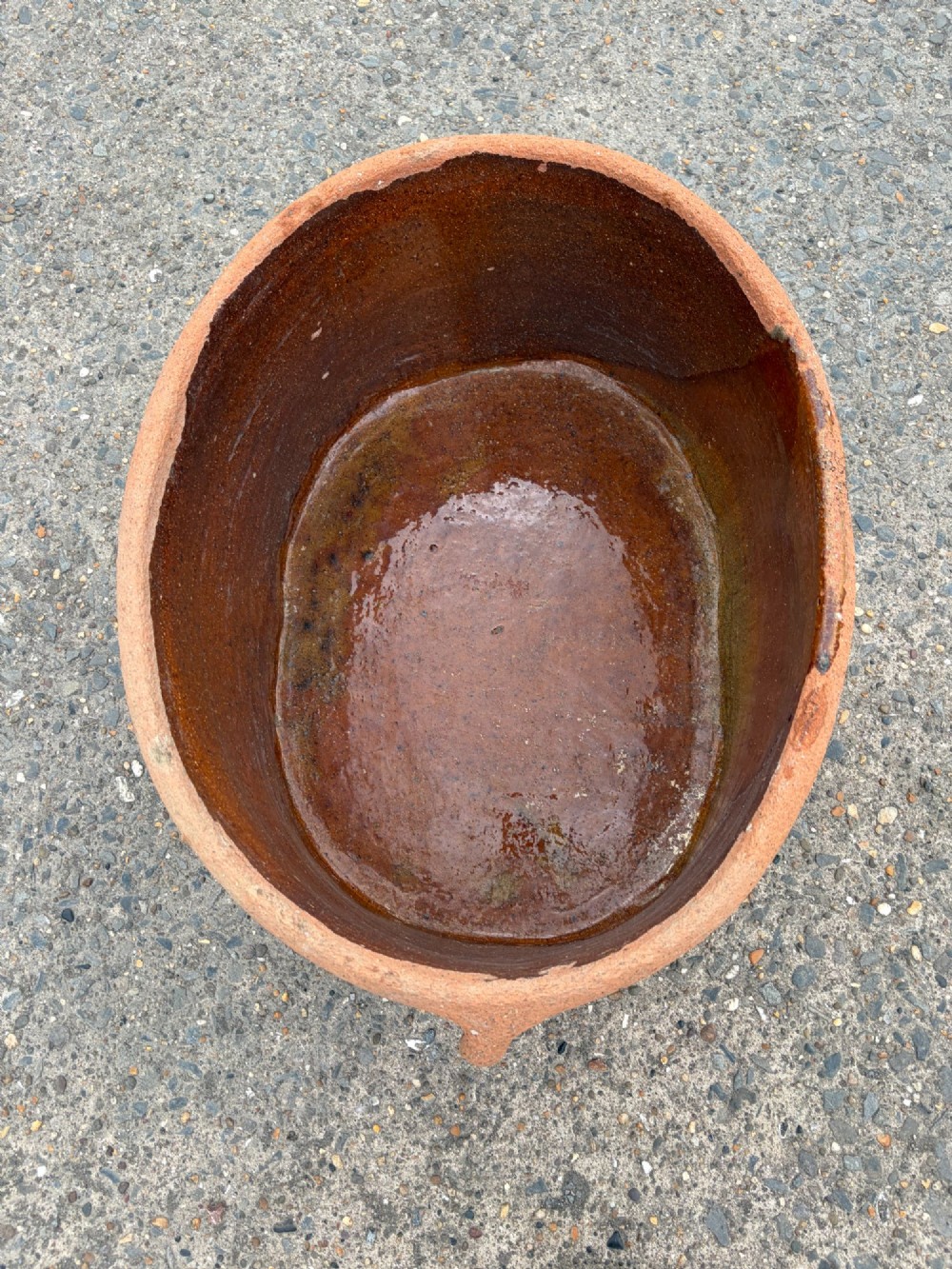 A large 19th-century oval terracotta salting trough with a weathered unglazed exterior and an amber lead-glazed interior. View IV