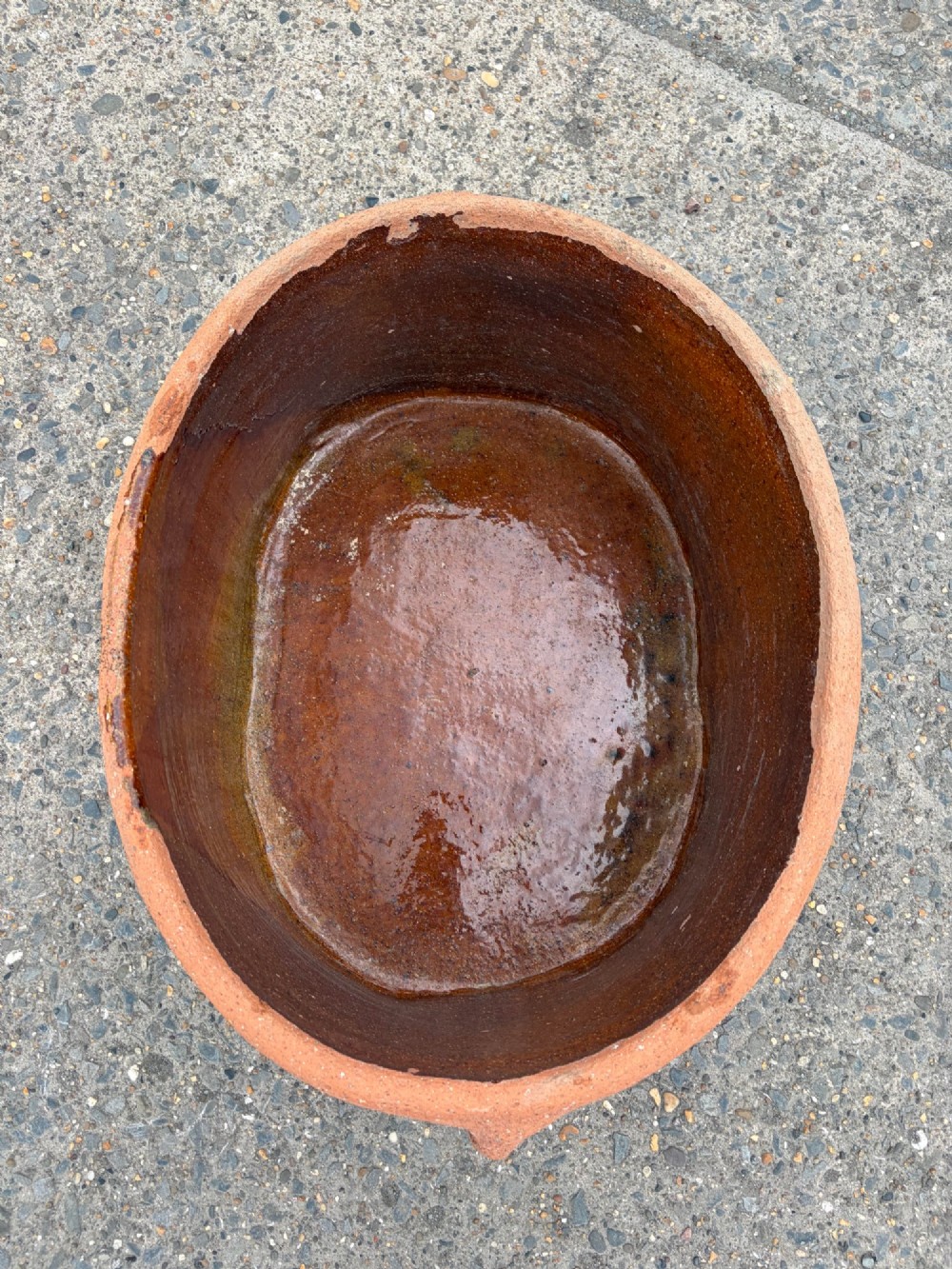 A large 19th-century oval terracotta salting trough with a weathered unglazed exterior and an amber lead-glazed interior. View VI