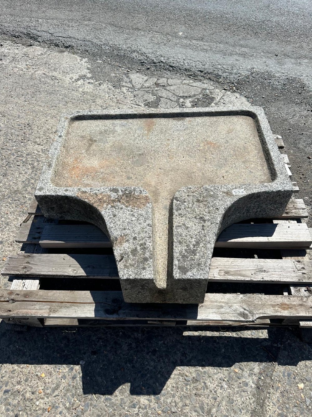 A hand-carved grey granite press stone featuring a recessed rectangular basin with an extended drainage spout. View IV