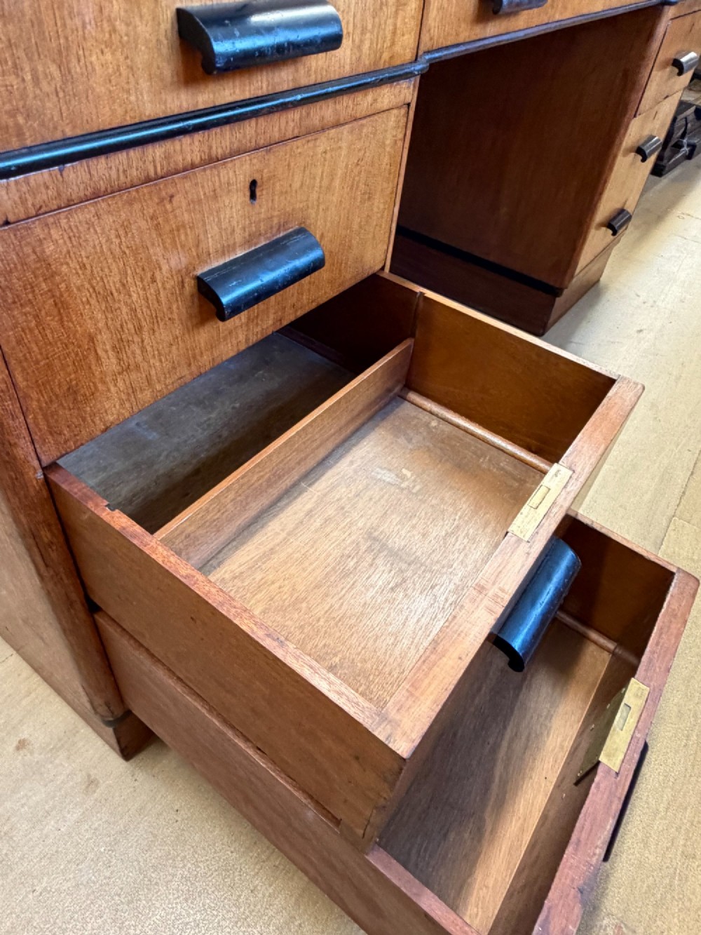 A large Art Deco walnut partner desk featuring a brown leather inset top and black horizontal drawer handles. View VI