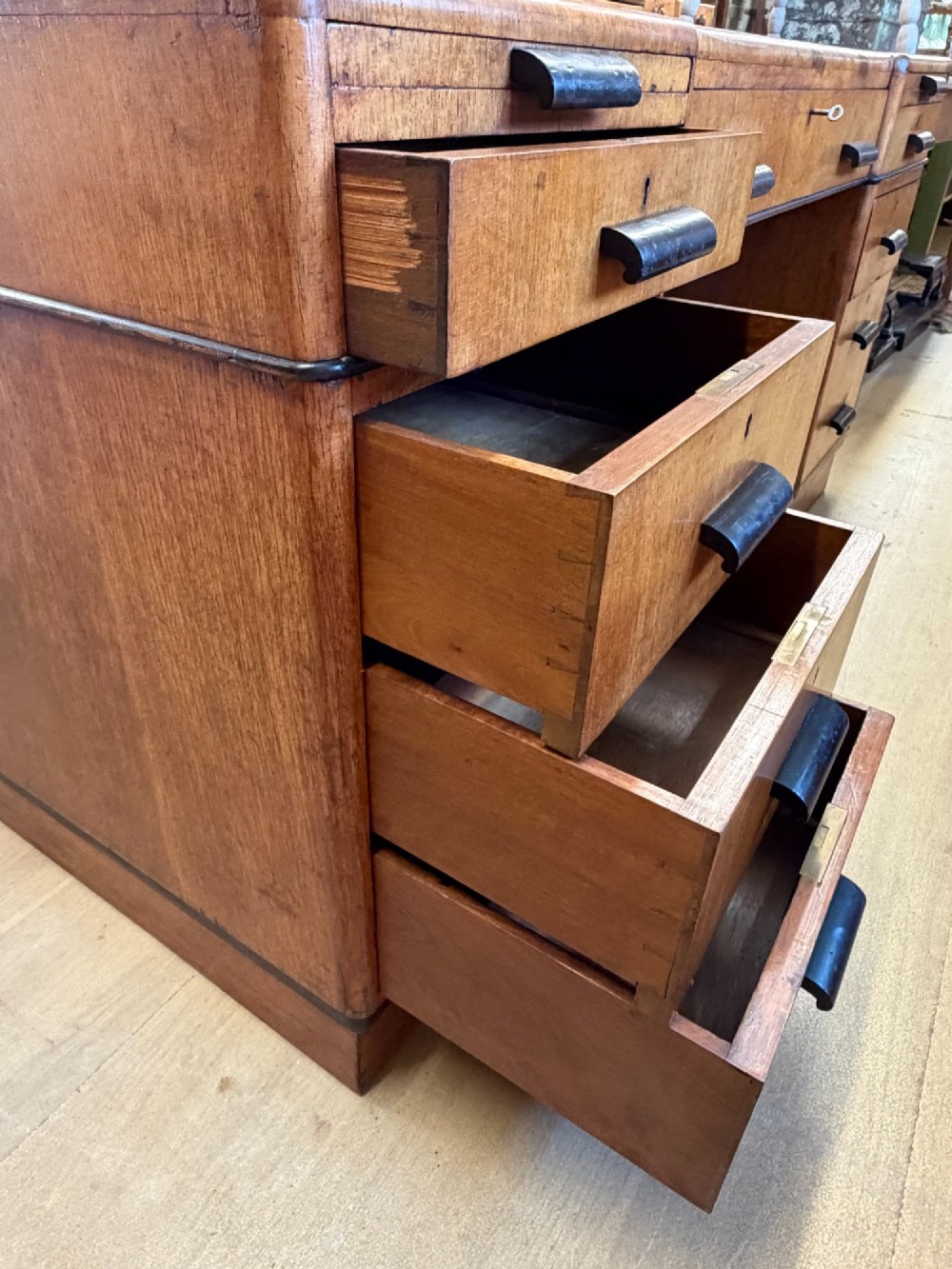A large Art Deco walnut partner desk featuring a brown leather inset top and black horizontal drawer handles. View VII