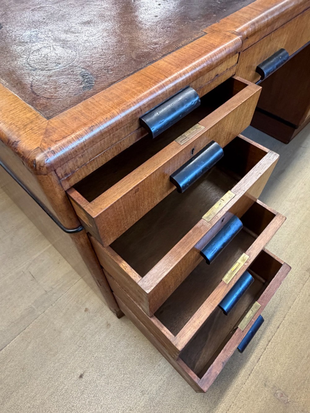 A large Art Deco walnut partner desk featuring a brown leather inset top and black horizontal drawer handles. View VIII