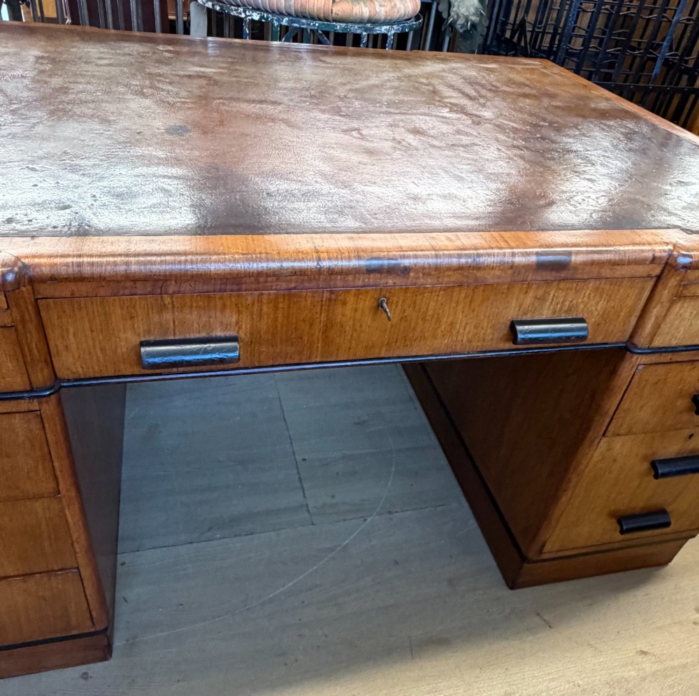 A large Art Deco walnut partner desk featuring a brown leather inset top and black horizontal drawer handles. View X